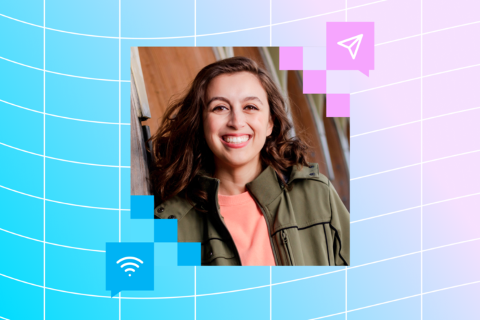 A woman smiling against a blue and pink background.