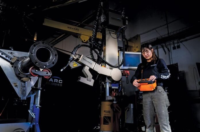 An operator uses a Novarc coil welding robot (SWR).