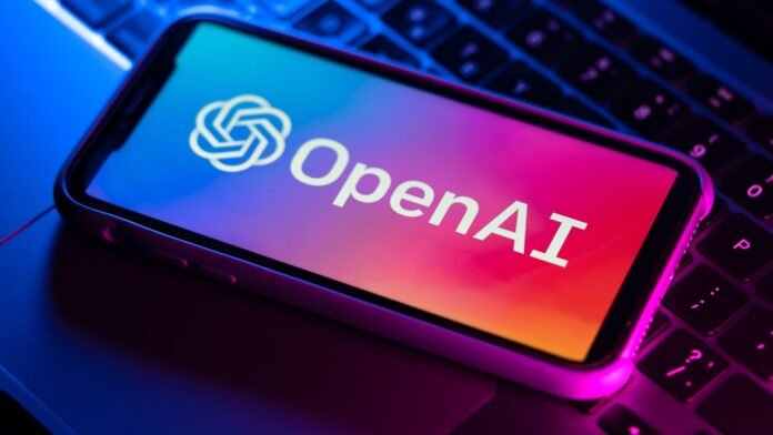 OpenAI logo on the phone on top of the laptop keyboard