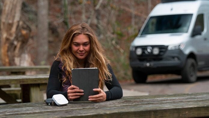 TravlFi hotspot next to woman with tablet