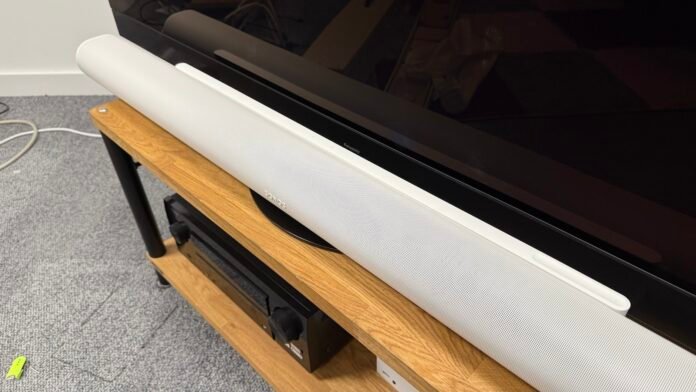 The Sonos Arc Ultra photographed on a wooden stand for a Panasonic Z95A OLED TV